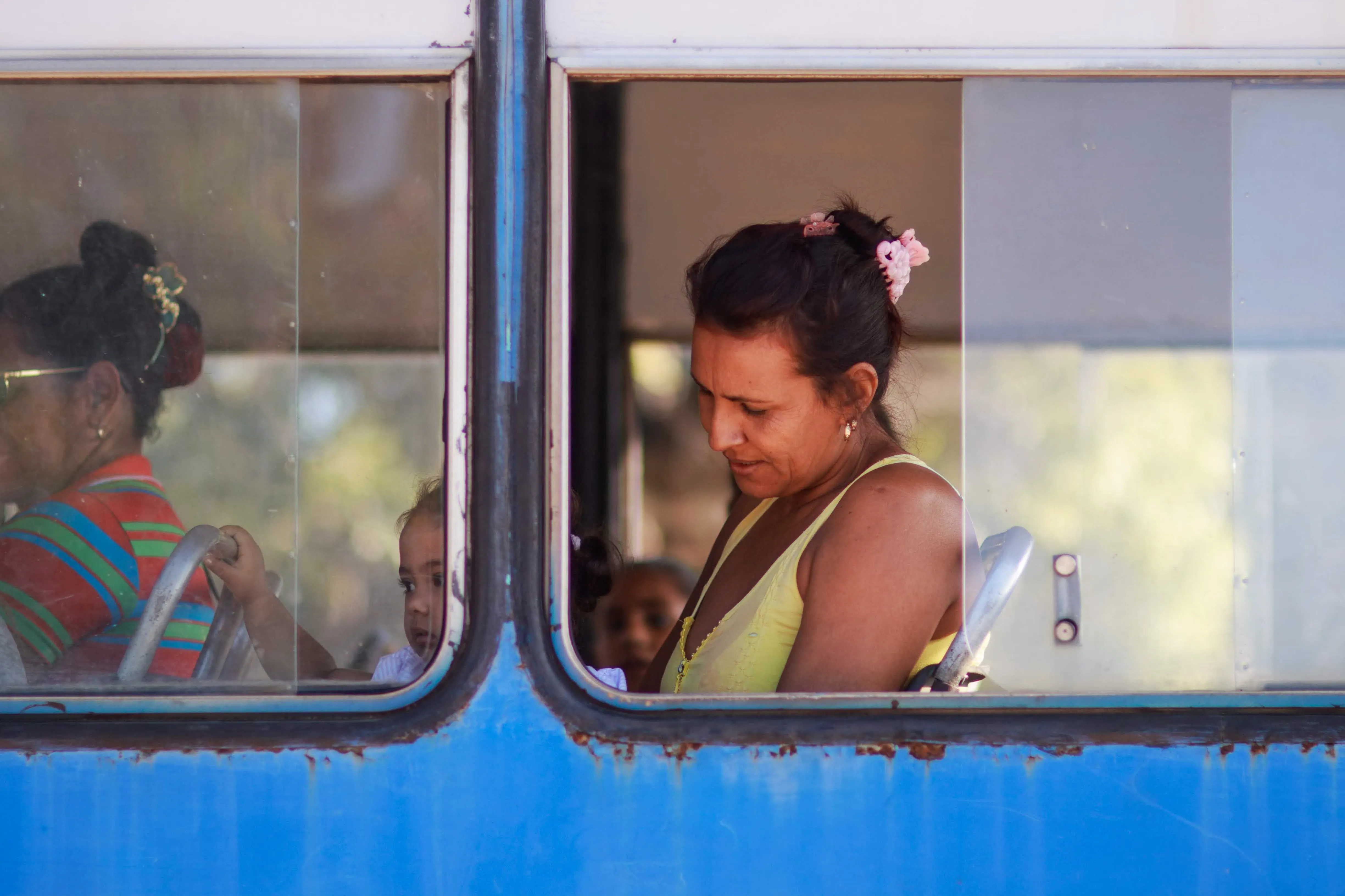 Mujer joven viajando sola mira por la ventana de un autobús con su mochila a un lado
